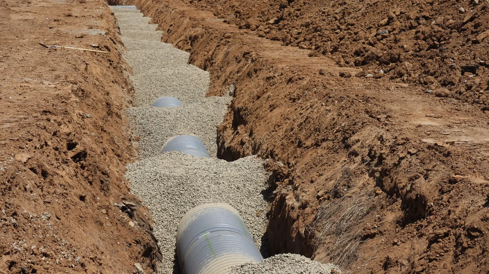 Drainage pipe laid on stone in an open trench