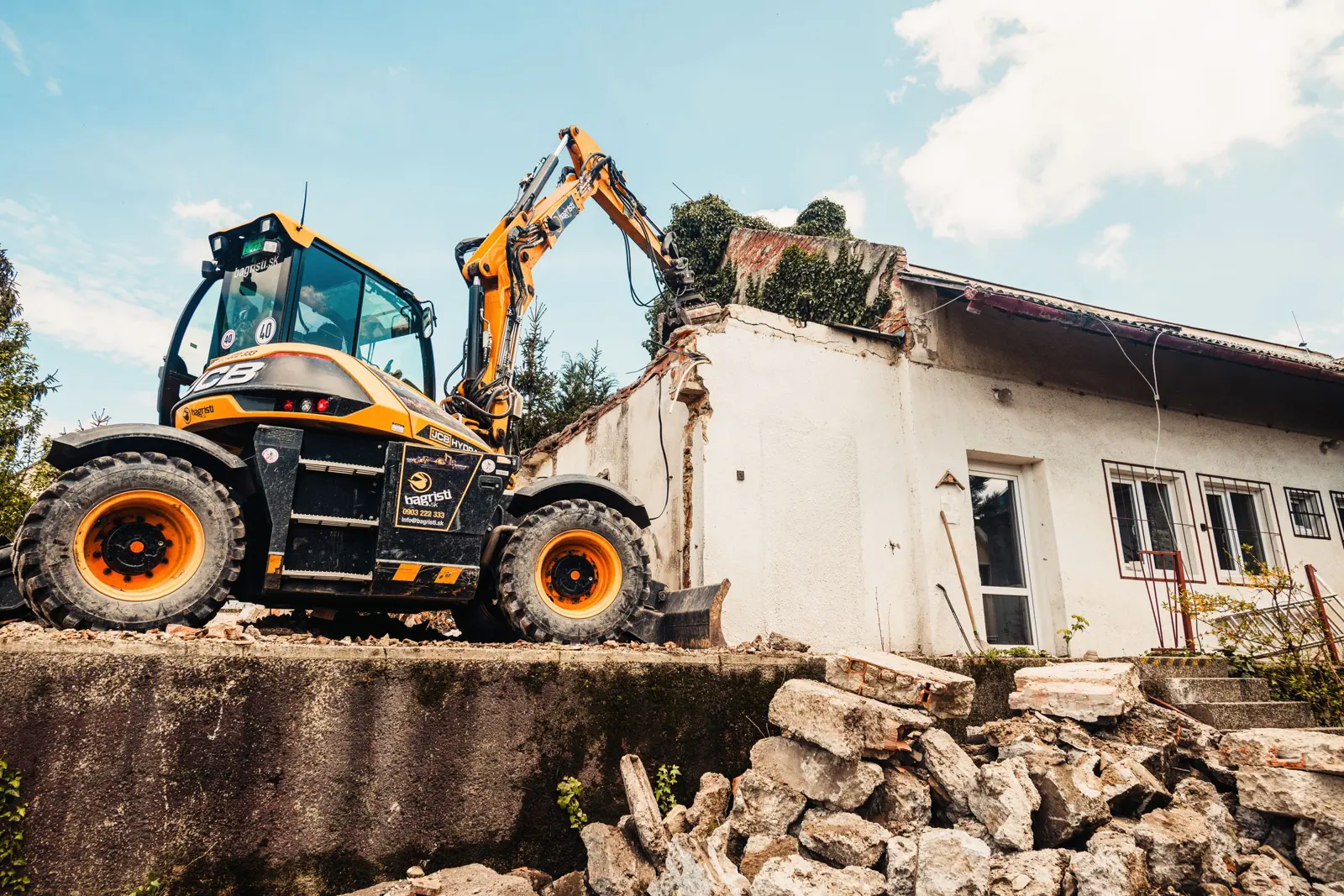 JCB wheeled excavator clearing a site