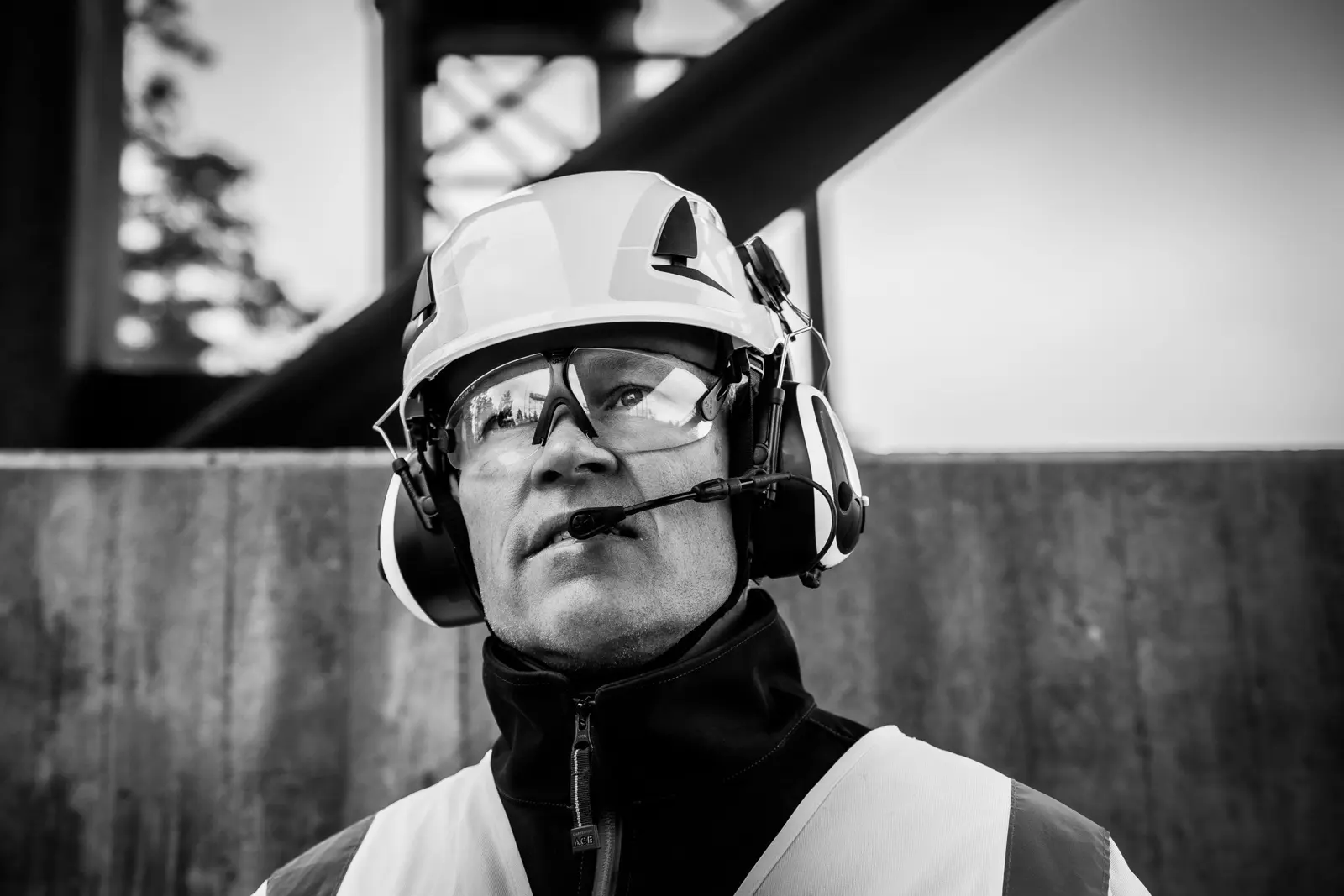 Site operative in hard hat and ear defenders
